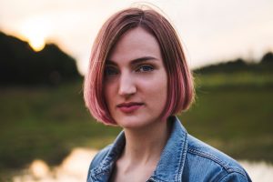 young woman outside with pink hair